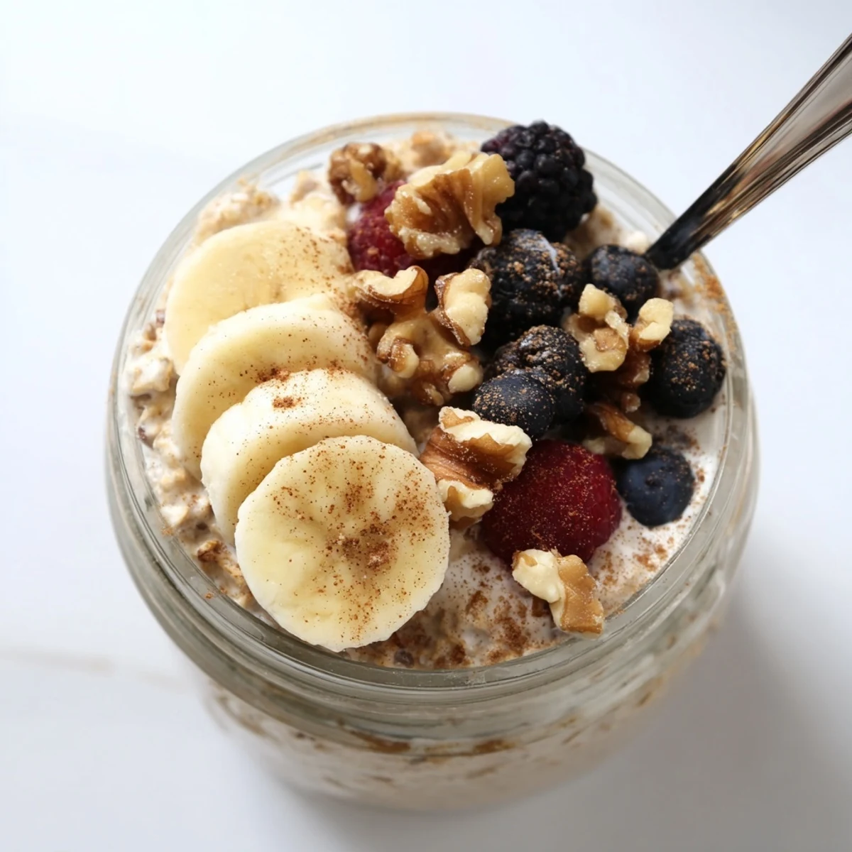Rich brown sugar overnight oats speckled with cinnamon and garnished with pecans in a clear container