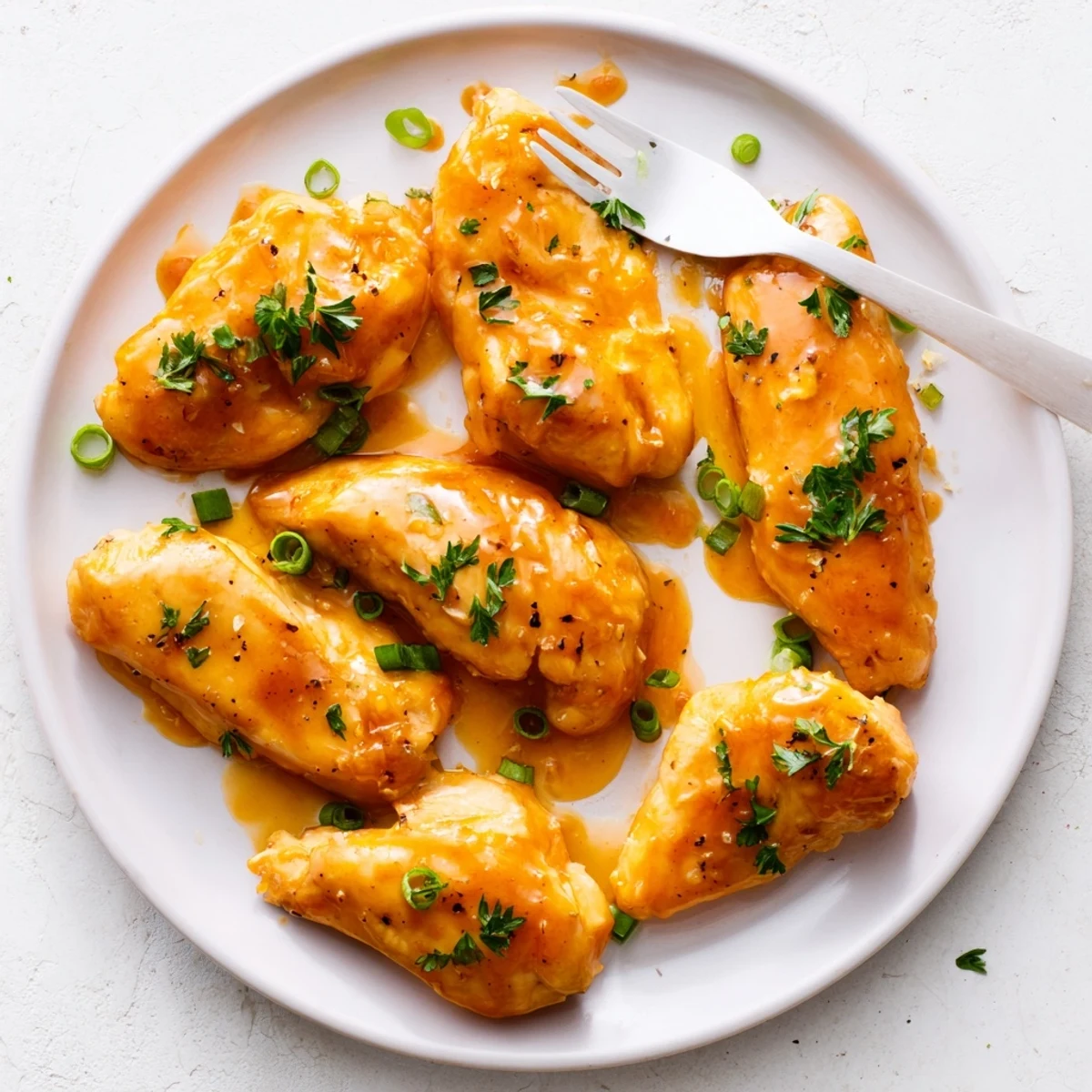 Golden glazed classic apricot chicken breasts garnished with fresh parsley and green onions