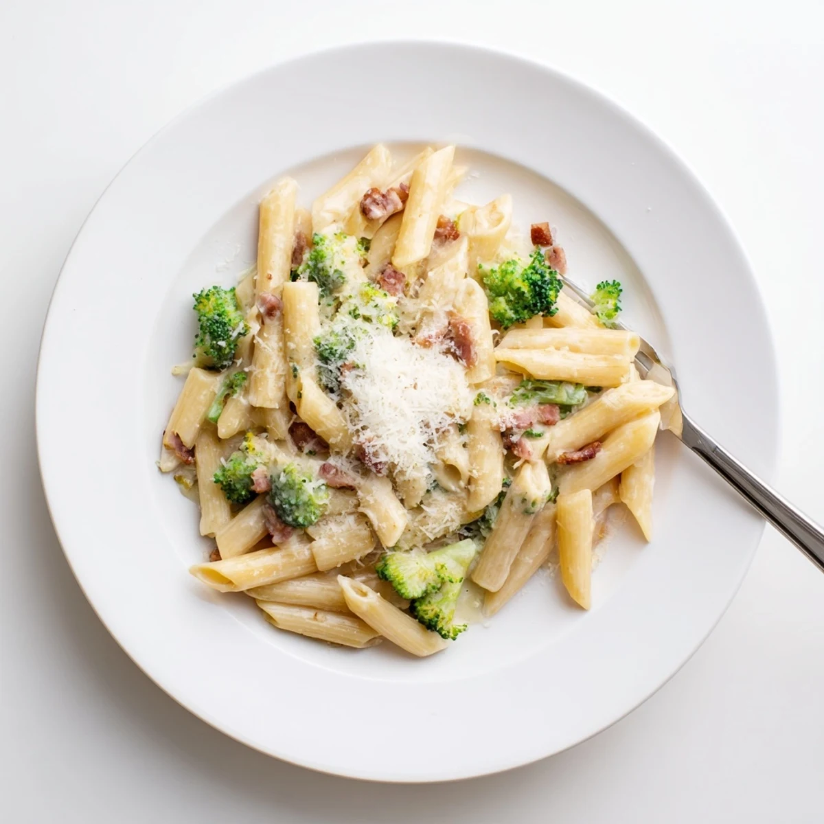 Golden penne pasta with tender broccoli florets and crispy bacon in a silky Parmesan cream sauce