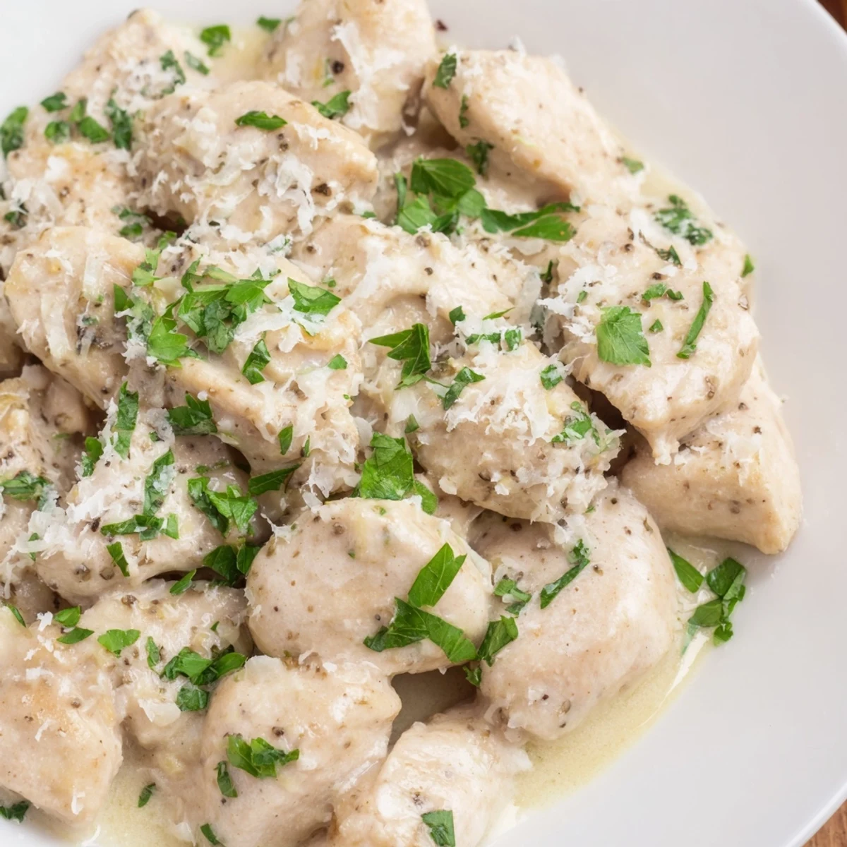 Savory Crockpot Creamy Garlic Parmesan Chicken topped with fresh parsley over fluffy mashed potatoes