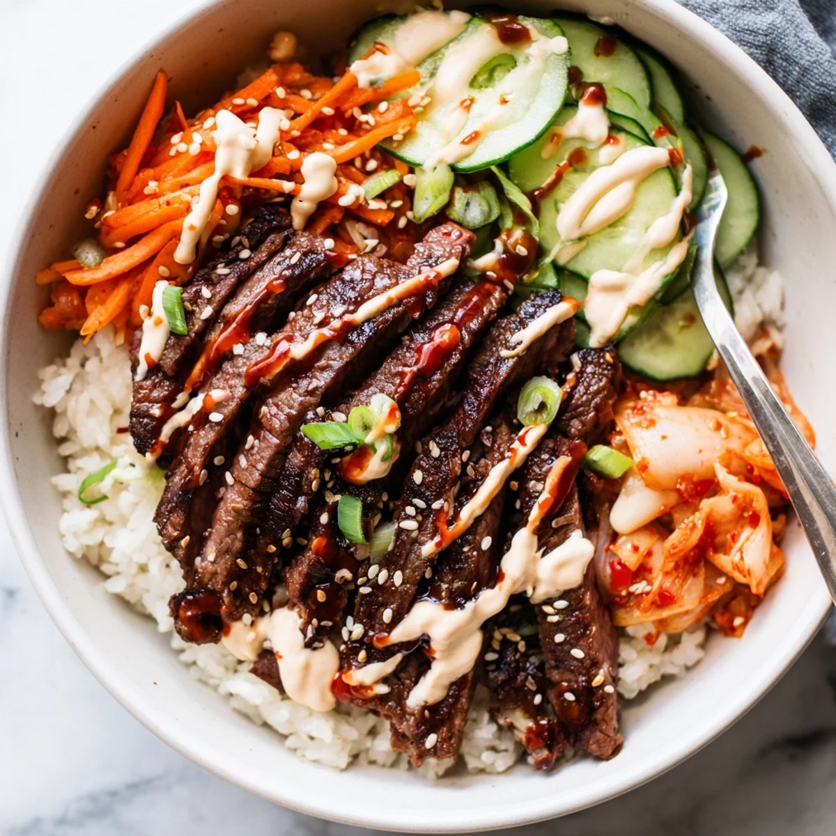Sizzling Korean BBQ steak rice bowls garnished with sesame seeds and tangy spicy cream sauce