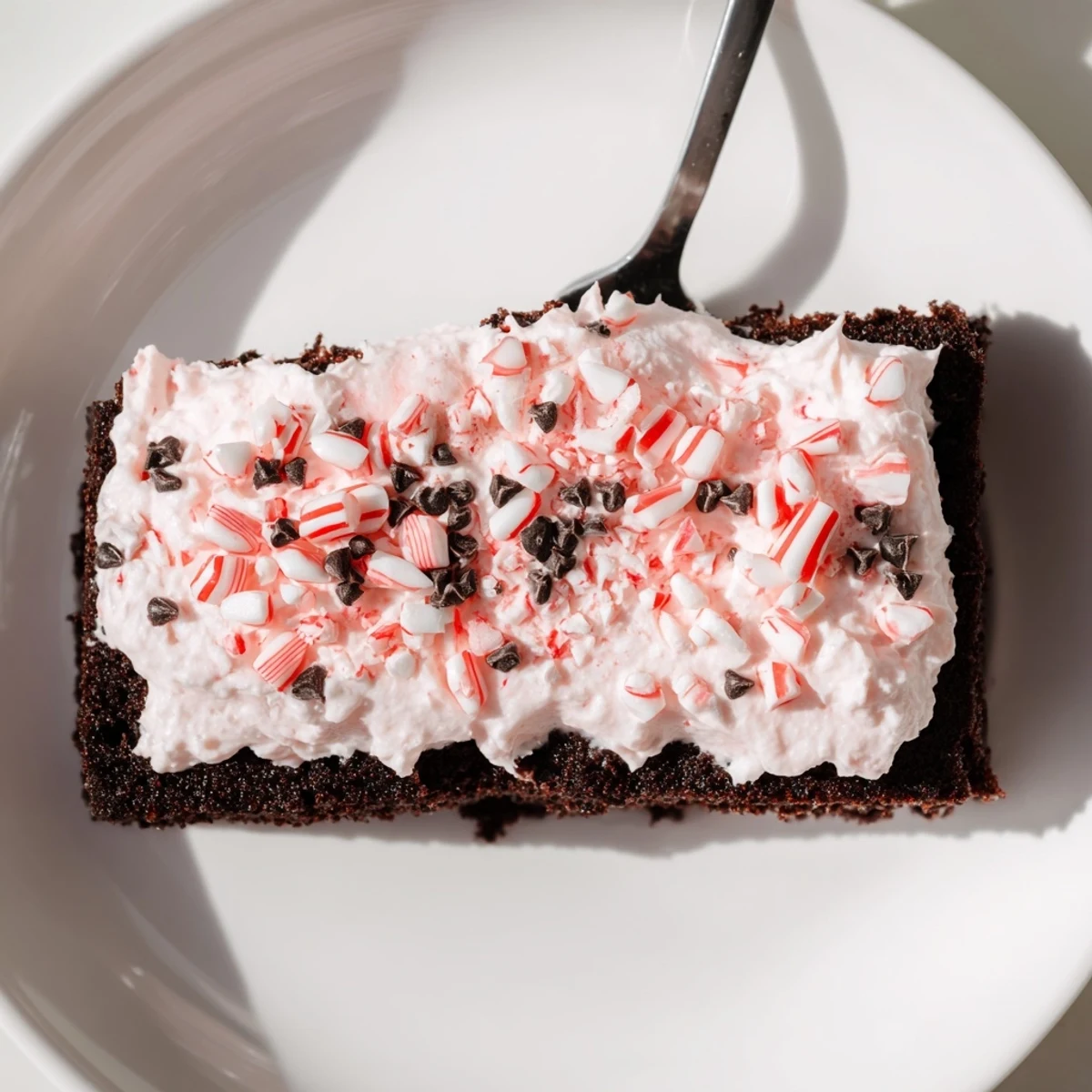 Holiday Peppermint Poke Cake garnished with chocolate shavings, perfect for parties