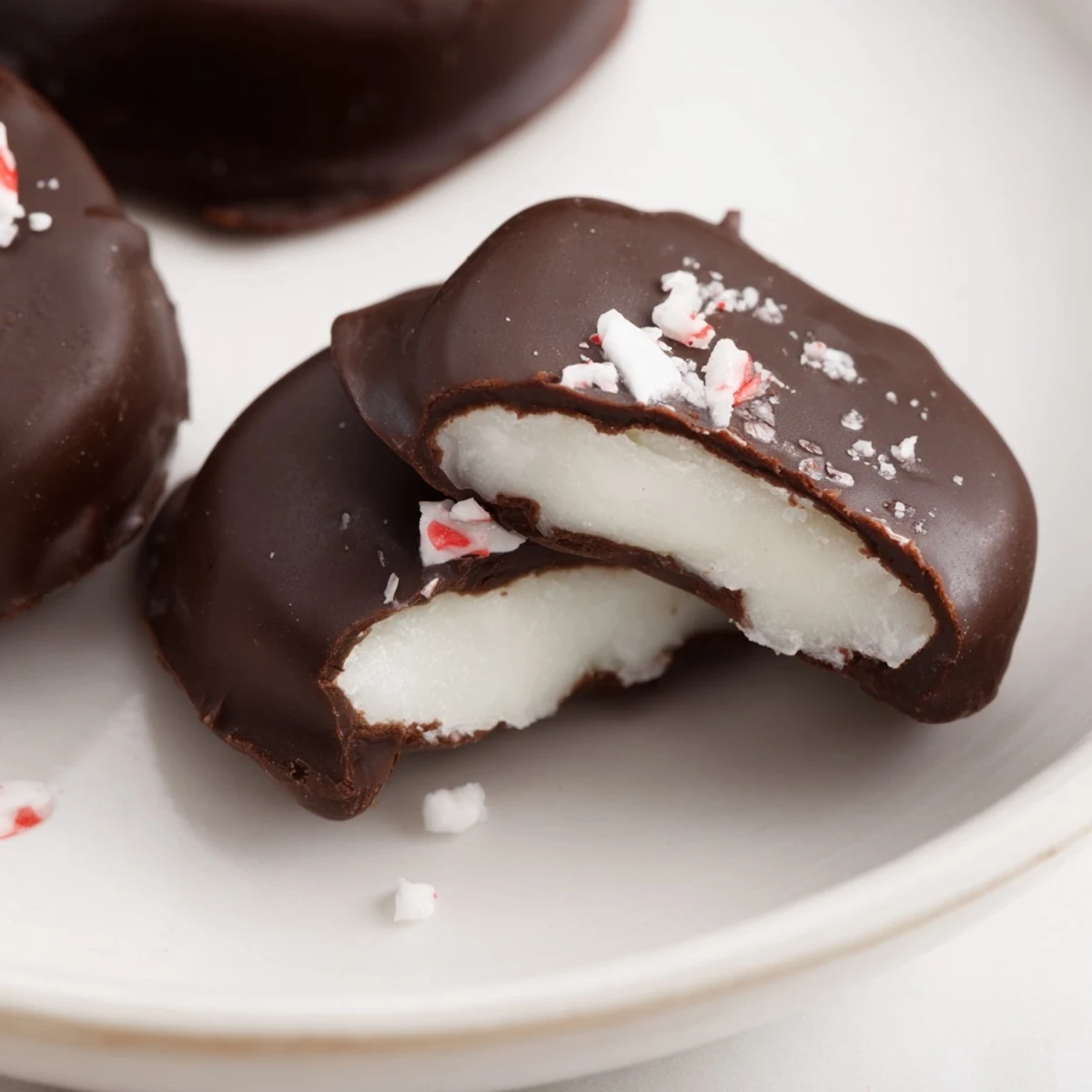 Peppermint Patties glistening with dark chocolate, stacked on parchment for gifting