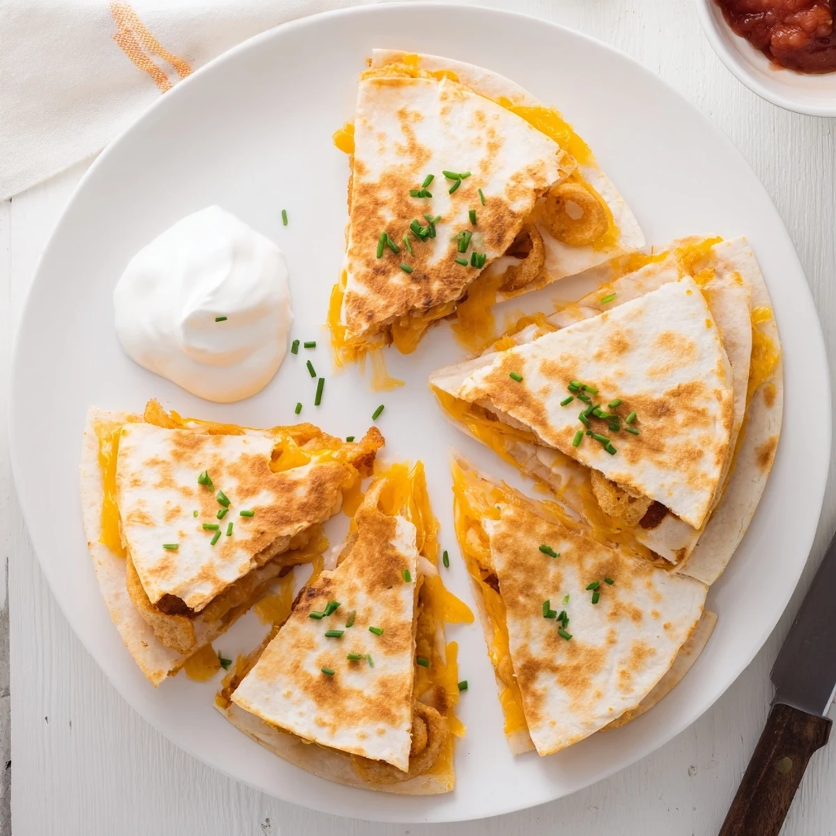 Crispy battered onion rings nestled inside cheesy folded tortilla with gooey melted cheese