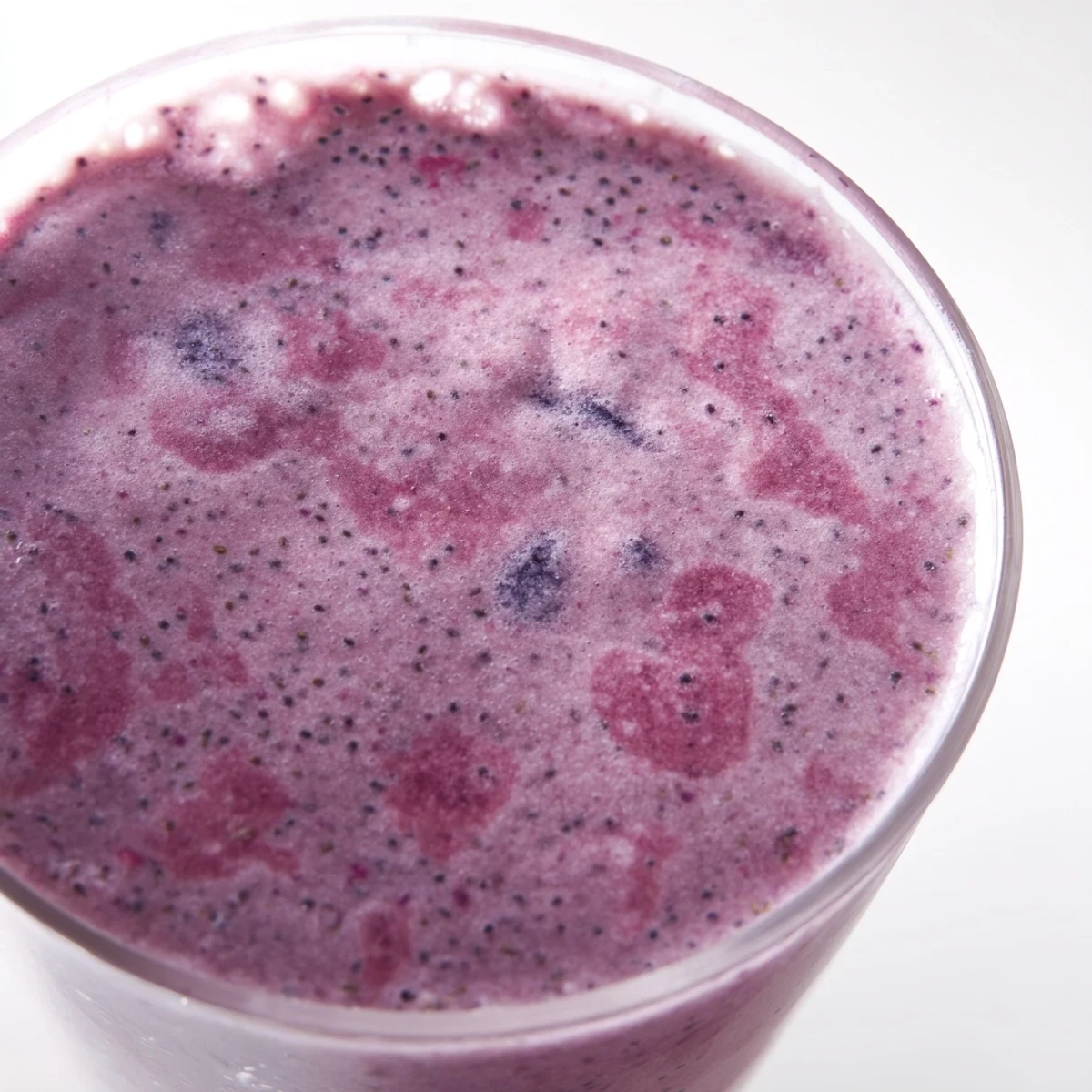 Creamy chia seed smoothie blended with frozen berries and banana served in clear glass jar