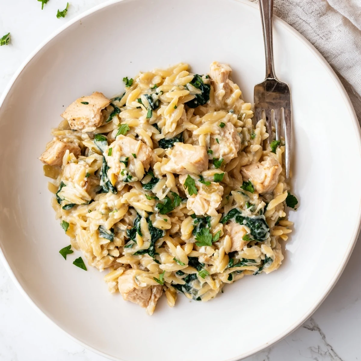 Creamy one pan Boursin chicken orzo with tender spinach in a rustic skillet