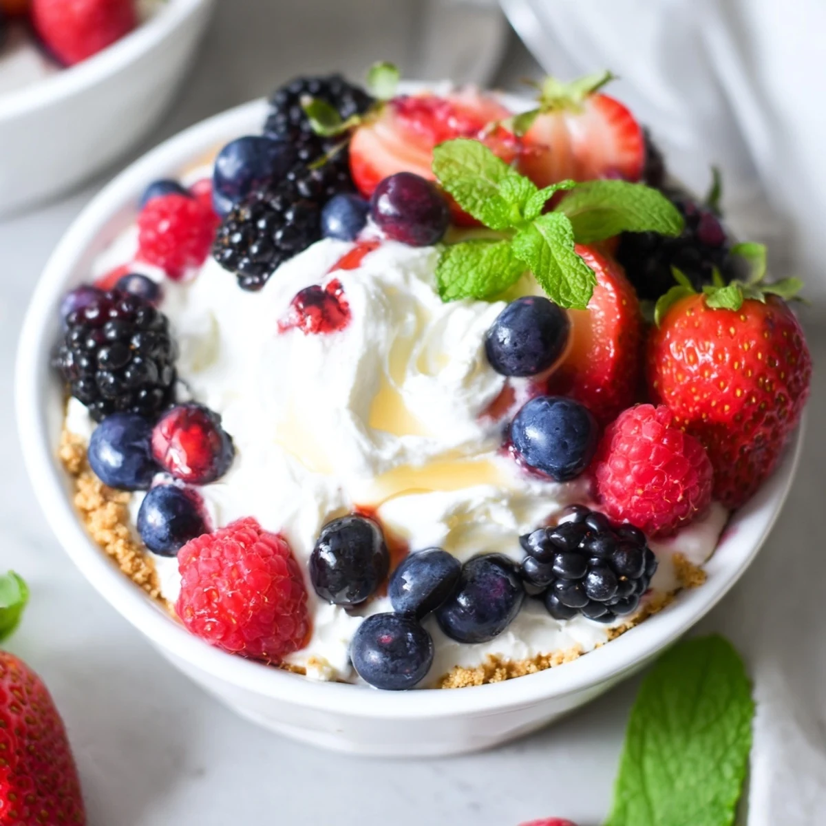 Creamy no bake berry cheesecake bowls layered with crushed graham cracker base and fresh mixed berries