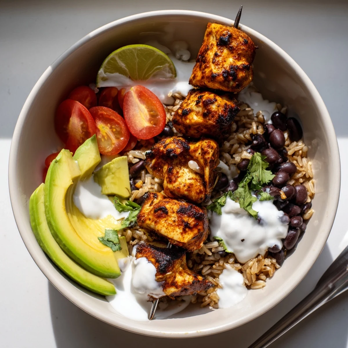 Colorful Smoky Chicken Skewer Bowl Recipe topped with zesty yogurt sauce, tomatoes