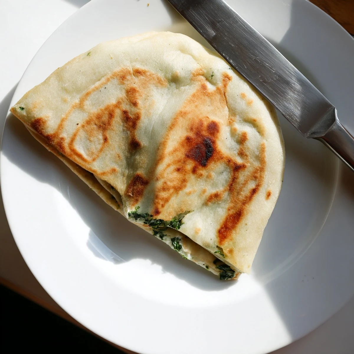Golden Turkish Gozleme with spinach and feta filling freshly cooked on a skillet