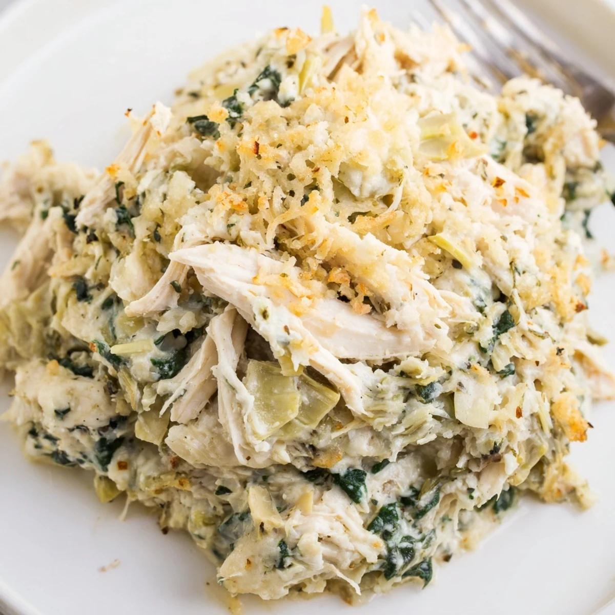 Hearty Spinach Artichoke Chicken Casserole sliced, served with crusty bread and salad