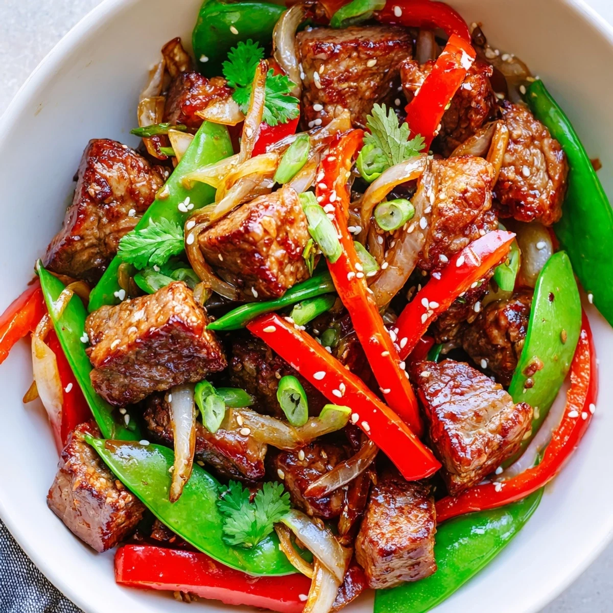 Golden seared Asian-inspired cube steak tossed with snap peas and bell peppers in savory sauce
